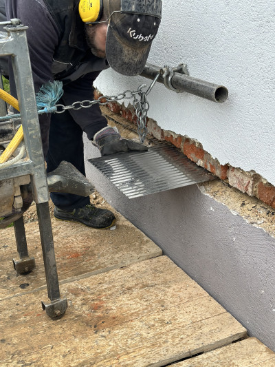 Mitarbeiter setzt neue Edelstahlplatte in Maschine ein.